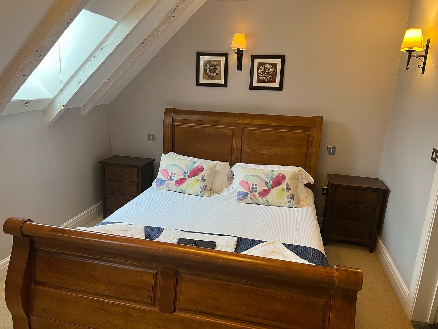 Accessible Ground-Floor room at The George Inn — oak sleigh bed with floral cushions and white linens
